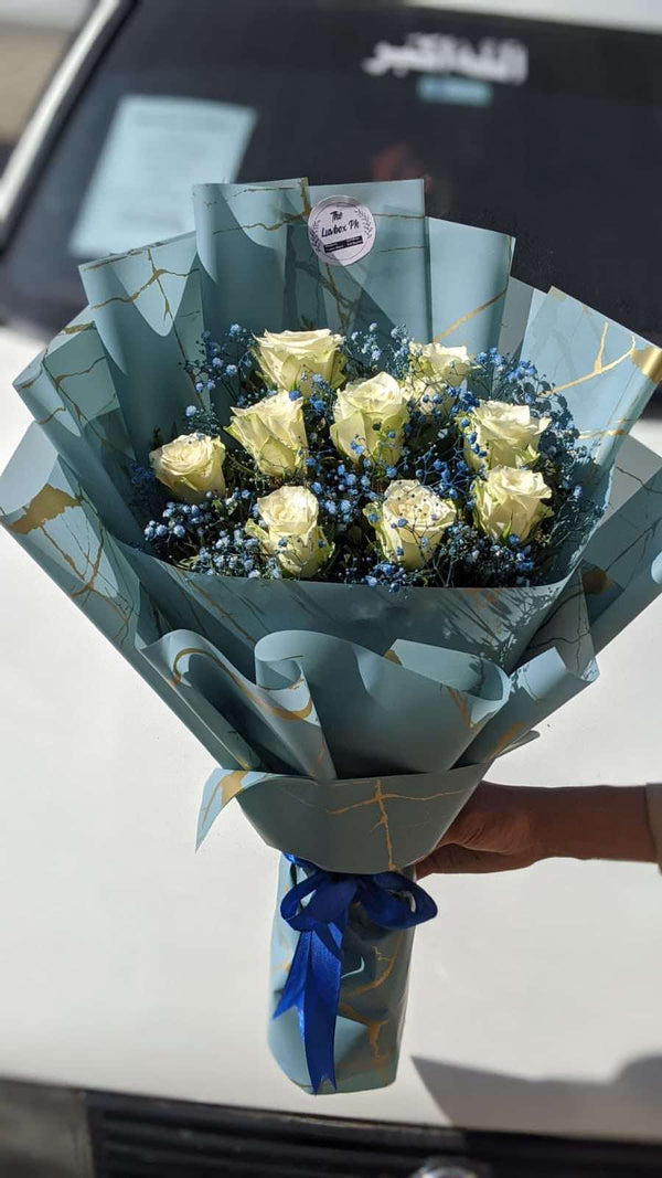 
Fresh white rose bouquet arranged with elegant deep blue wrapping for a sophisticated gift
