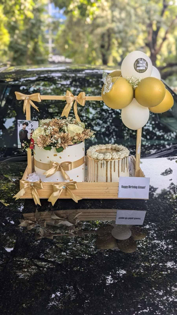 Elegant wooden gift basket featuring a 2 lbs cake, fresh flowers and mini balloon decorations