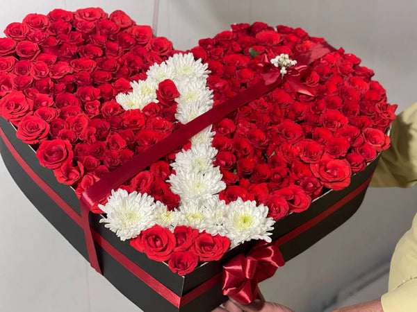 Heart-shaped box filled with 150 plus red roses and a custom white flower number design