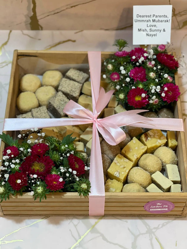 Eid mithai gift tray with traditional Pakistani sweets flowers ribbon and Eid Mubarak topper in Islamabad