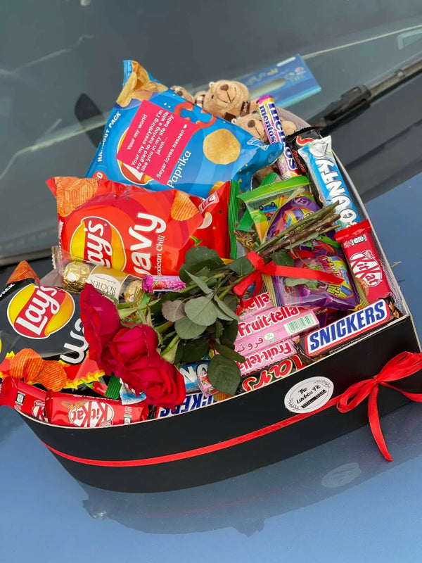 Heart-shaped gift box with red roses chocolates and assorted snacks for delivery in Islamabad