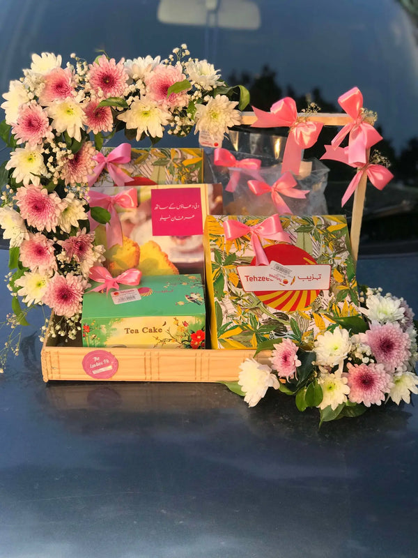 Wooden gift tray with Tehzeeb Bakery snacks and fresh floral decoration in Islamabad